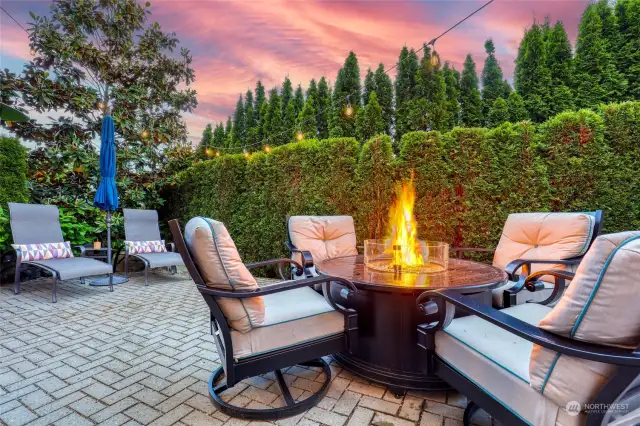 Talk about summertime fun!! Soak up the sun in the privacy of your backyard. Low-maintenance landscaping. Garden string lights, custom paver patio, small water feature adds a nice ambiance as well as a fire table like the one pictured. There's a gate from this area to the driveway on the right side of the patio table.