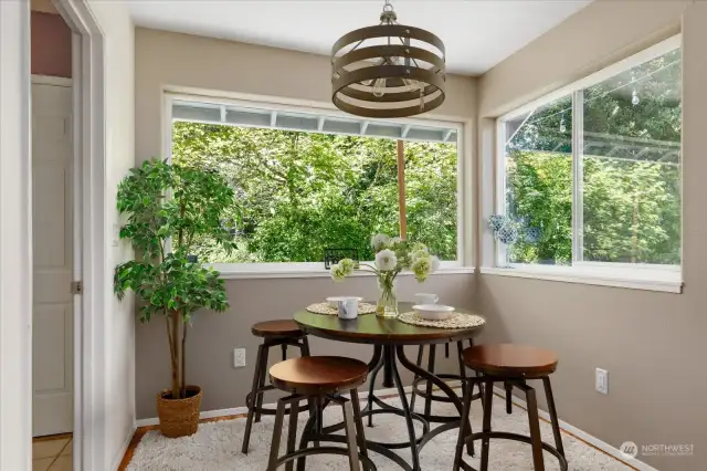 Dining area surrounded by large windows, providing a bright and inviting space for dining and entertaining. Let's go check out the downstairs bath and bedroom/office space next!