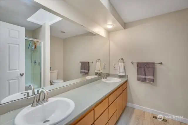 The primary bath has a large double vanity with lots of storage and a shower.