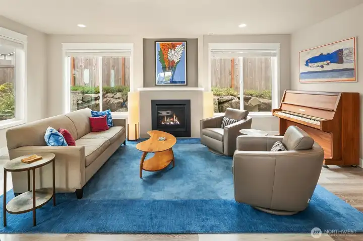The spacious living room is full of light. The large, plentiful windows feature Norman wood blinds.