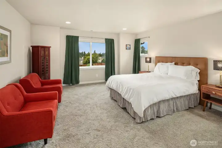 The upper floor primary bedroom offers plenty of space for your furniture and even some mountain views when the weather cooperates!