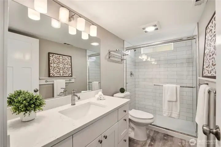 The lower level 3/4 bathroom is also completely remodeled with Quartz countertop, undermount sink, soft close cabinets and drawers, new fixtures and tiled shower surround.