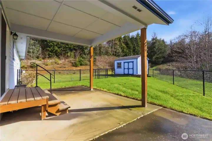 Back covered patio inside fenced dog run.