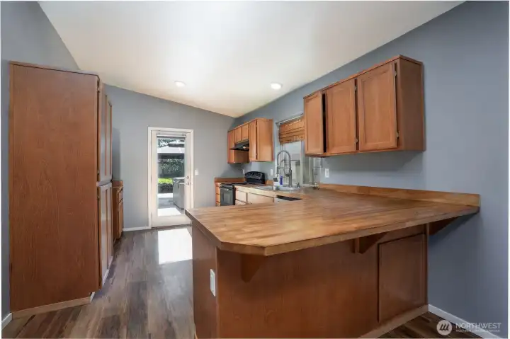 Ample cabinetry, generous counter space, and direct access to the backyard make this kitchen both functional and convenient.