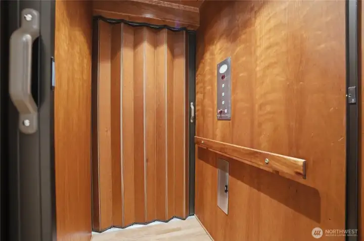 Cherry-paneled elevator cabin. The elevator can be accessed from all three levels of the home.