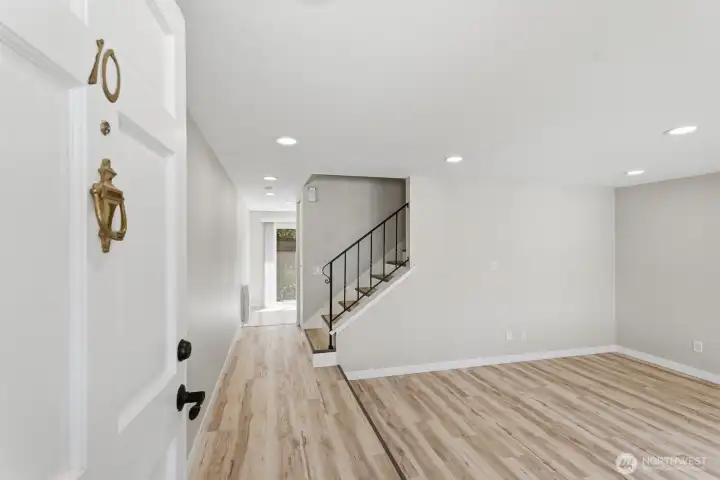 Entryway opens to a large living room on the right and kitchen/eating nook straight ahead.