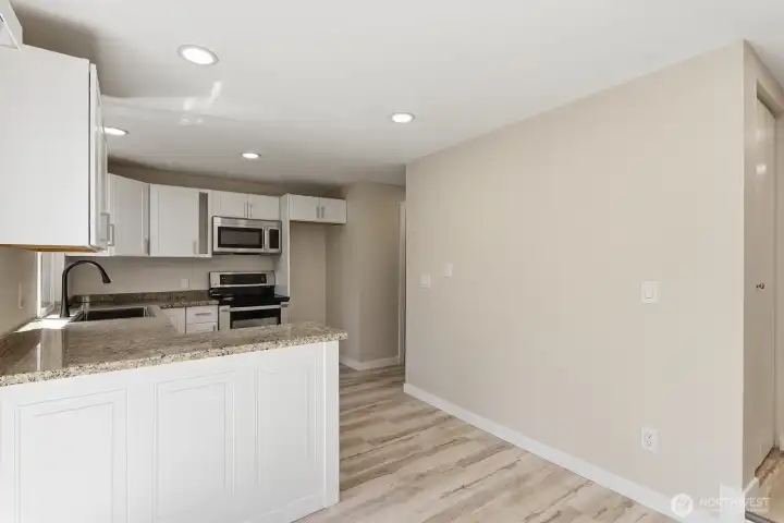 Fully remodeled kitchen has new cabinetry, granite countertops, stainless steel appliances and an eating nook.