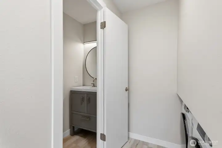 Main floor 1/2 bath with laundry washer/dryer across hall.