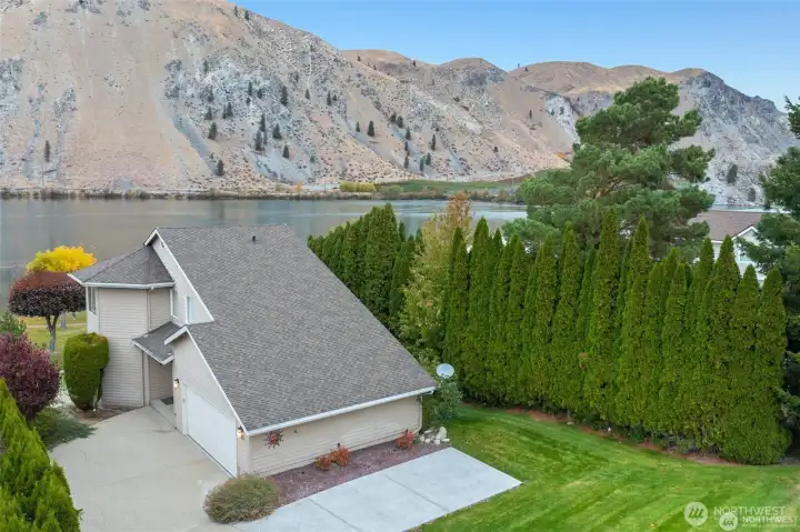 Oversized garage and generous driveway provide ample parking and storage space for vehicles, water toys, and outdoor gear.