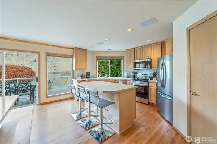 Bright kitchen with water views and direct deck access offers the perfect blend of functionality and entertaining space for everyday lakefront living.