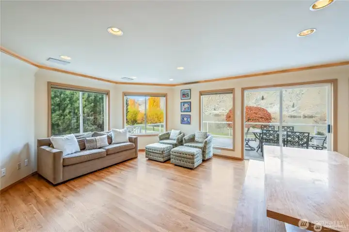 Light-filled living and dining spaces capture serene water views and offer direct access to the expansive deck, blending comfort and connection in this thoughtfully designed lakefront home.
