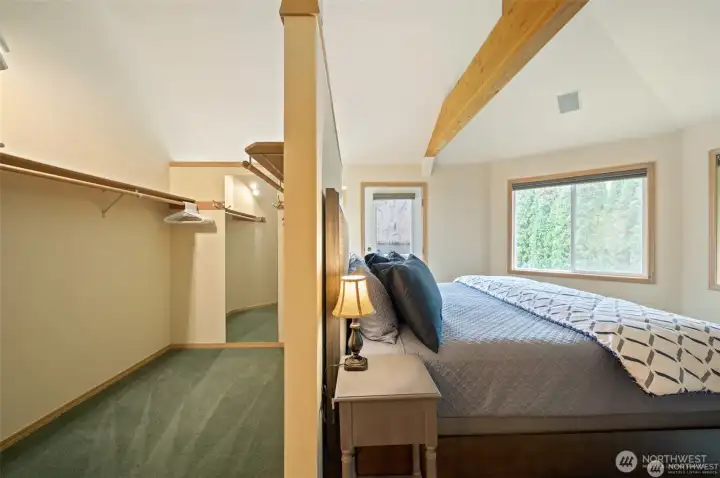 Expansive primary suite features vaulted ceilings, exposed beam accents, and an oversized walk-in closet designed for effortless waterfront living.