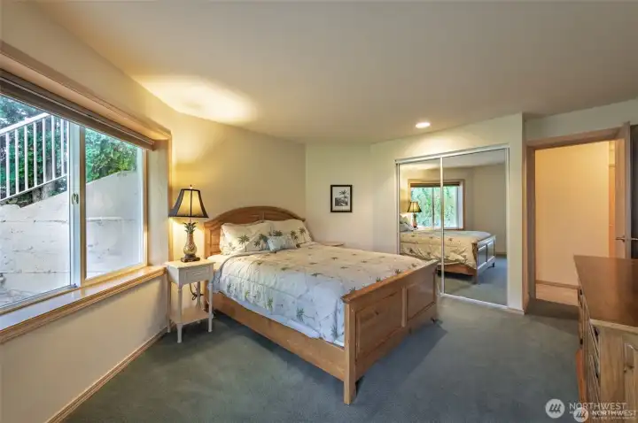 Lower-level guest suite offers private exterior access, peaceful water views, and comfortable accommodations for guests, extended stays, or multi-generational living.