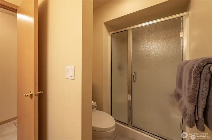 Guest bathroom includes a spacious walk-in shower and clean contemporary finishes, offering comfort and convenience for family and guests alike.