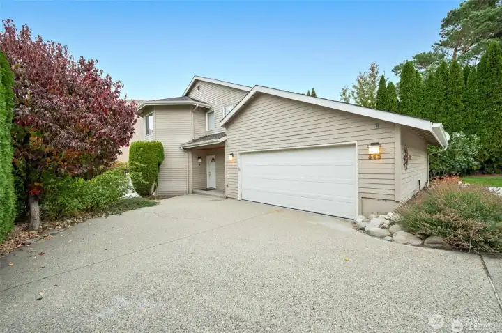 Welcoming exterior with EV-ready garage, low-maintenance landscaping, and ample parking for vehicles, boats, and lake toys—ideal for full-time living or a Columbia River getaway.