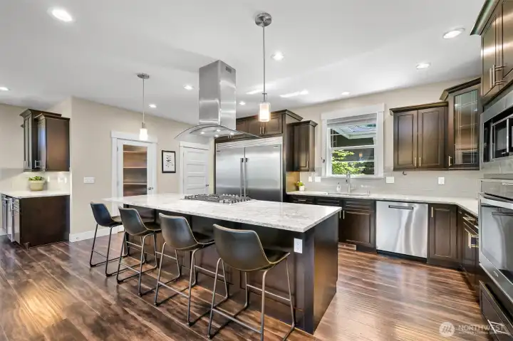 Impressive chef's kitchen with quartz countertops, a walk-in pantry, beverage fridge and beautiful stainless appliances