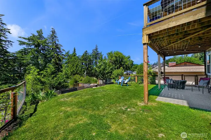 Sliding glass door from the downstairs leads to your backyard, with a fire pit, two apple trees, bonus space below for your dream garden or kids' play structure