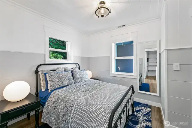 A peaceful perch tucked beneath the eaves, this cozy bedroom blends classic shiplap charm with layered textures—inviting quiet mornings, cool sheets, and deep, restful sleep by the sea.