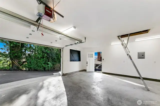 Perched just above the main residence, the 520 SF Coach House offers secure garage parking for two vehicles, with additional space for tools or a small workshop. Recent upgrades include a new roof, LED lighting, epoxy-sealed concrete floors, and a 200-amp electrical panel—ideal for modern shop needs or future EV charging. A finished attic loft provides added storage, while the private stair connection to the main home offers both convenience and a sense of cohesion across the property.