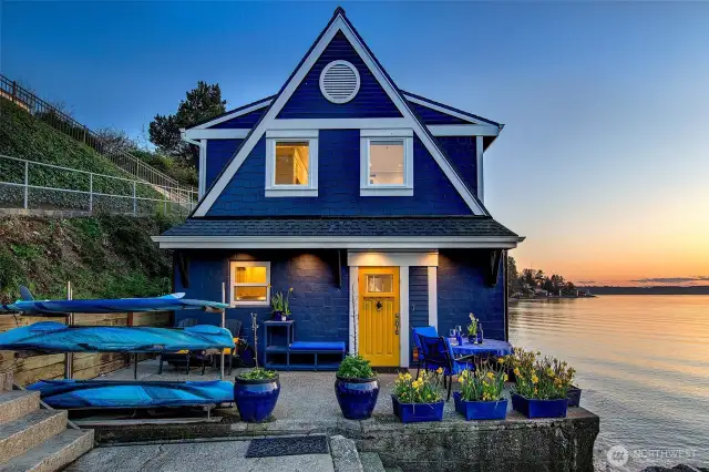 Evening sets the scene at the Beach Cottage, where daffodils lean toward the tide, wine glasses catch the last light, and a golden door beckons you inside to continue the story.