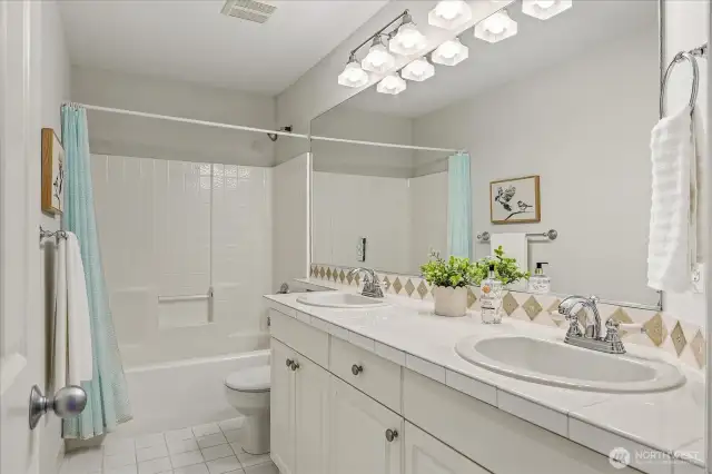 Hallway Guest Bath with dual vanities and ample storage.