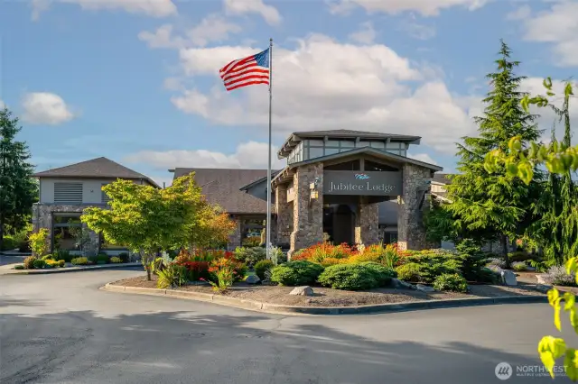 Photo of the exterior of the clubhouse which has a private weight room, satwater pool & various clubs at the lodge.