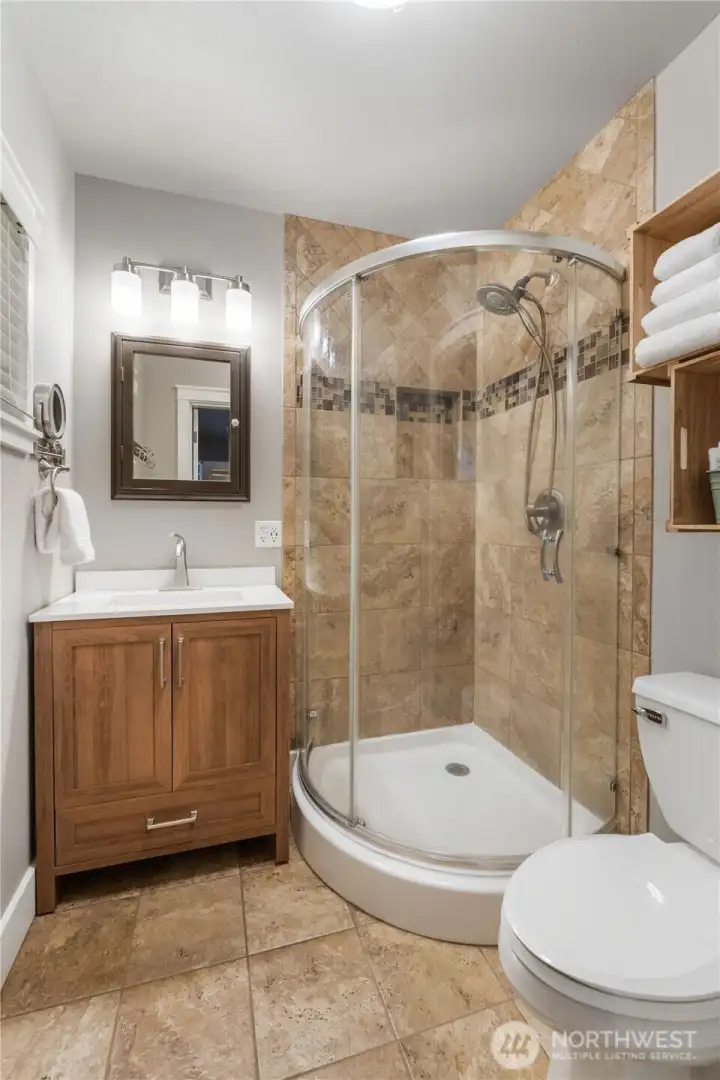 Primary bath with tile floor and shower surround.