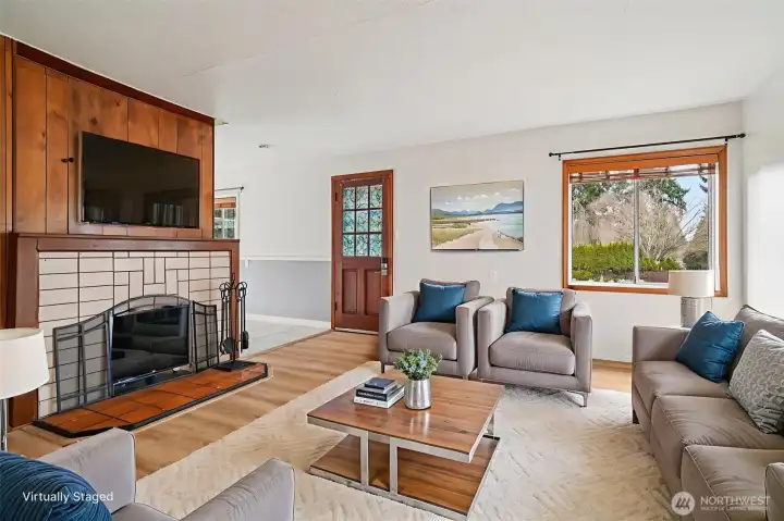 Large living room with wood burning fireplace and new flooring