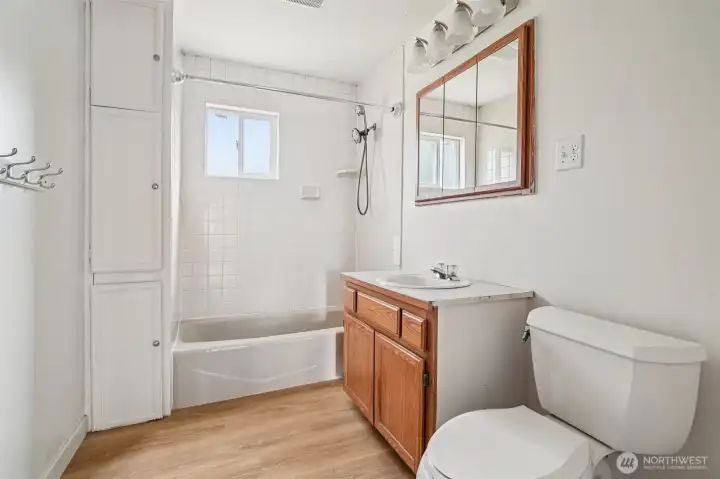 Full bath with tile tub surround and new flooring