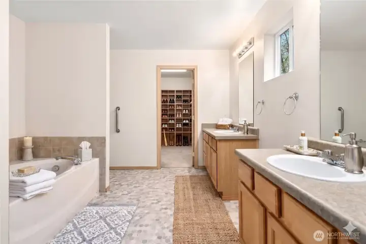 Owners suite bathroom with soaking tub and huge walk in closet with built ins
