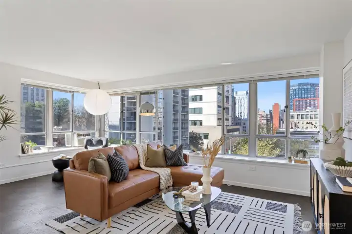Living Room - Large extended room with plenty of light from windows all around. Lots of different spaces to highlight art, nook for a reading area, or just relaxing while enjoying the city views down Seneca Street to the waterfront.