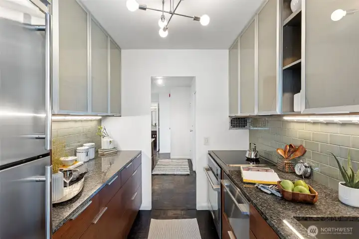 The designer kitchen features glass-front cabinetry, granite surfaces, and premium appliances including Fisher & Paykel, Miele, Electrolux, and Northland.