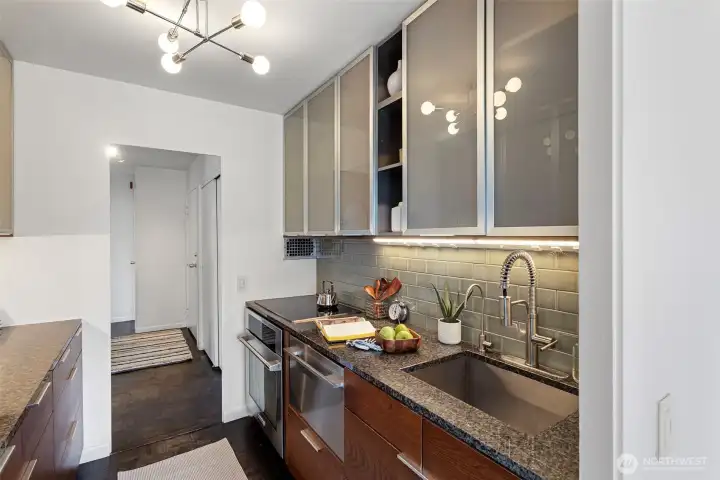 Chefs kitchen with an abundance of glass front cabinets, drawers and quartz counters. High-end stainless appliances include Northland fridge-freezer, Electrolux oven, Miele cooktop and Fisher Paykel dishwasher.