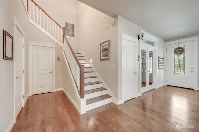 Grand entryway welcomes you with gleaming hardwood floors and a striking staircase, with ample storage underneath, leading to the upper level.