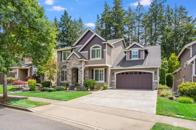 The spacious driveway leads to a three-car garage, providing ample parking and storage space.