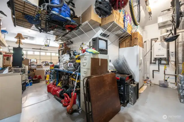 Three-car garage provides ample space for vehicles, storage, and a workshop area behind the first parking space.