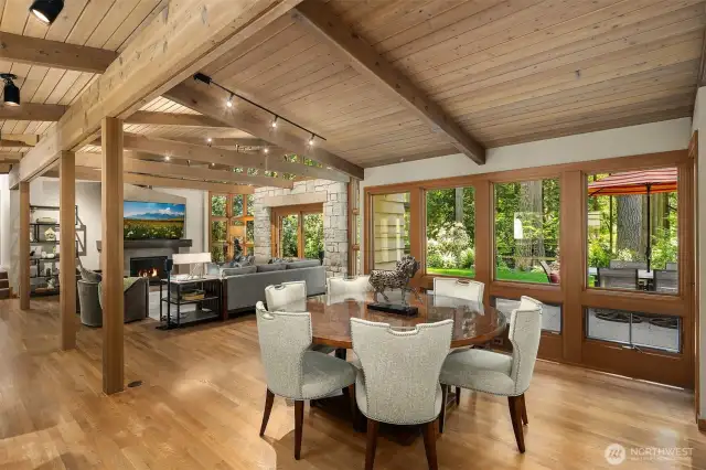 Open concept great room with vaulted wood ceilings, exposed beams, walls of windows and access to the entertainment patio