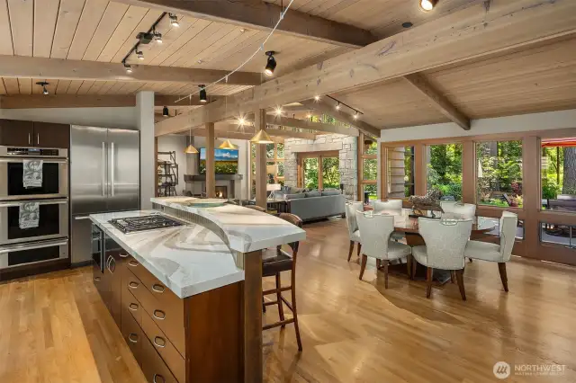 Open concept great room with vaulted wood ceilings, exposed beams, walls of windows and access to the entertainment patio