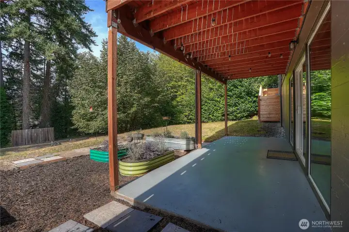 Covered patio & stairs beyond access up along the side of the home to the garage area…