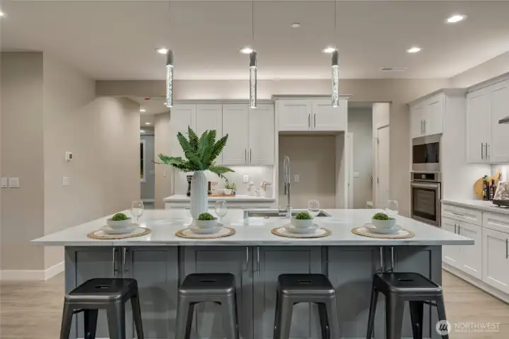 Anchoring the kitchen, the expansive island offers an elegant gathering spot for casual meals, entertaining, or lively conversation with family and friends.