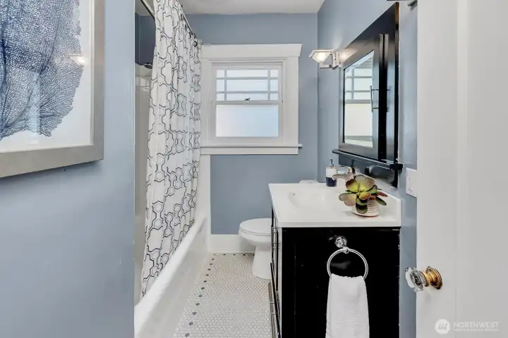 Main floor bathroom with original tile floors and bathtub