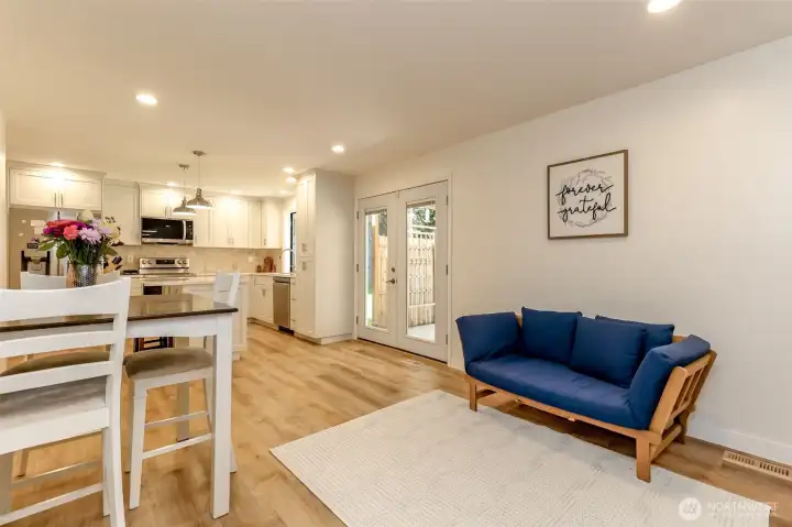 Dining and living room facing kitchen and French doors.