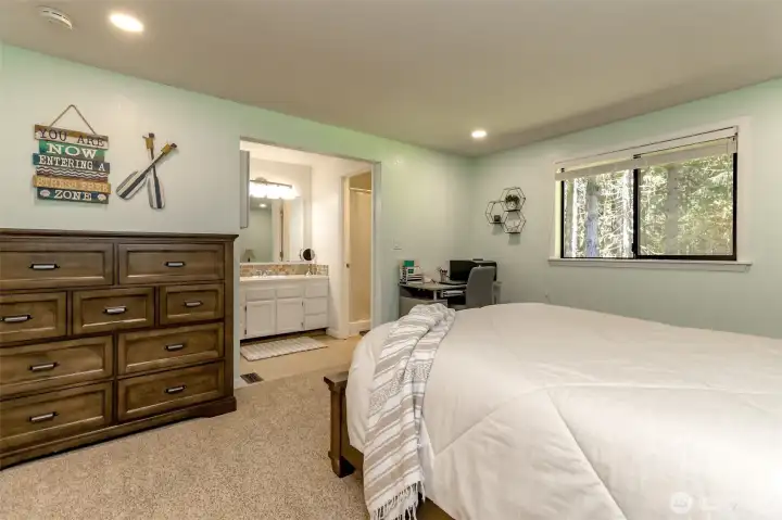 Primary vanity with oak in closet to the left and water closet & shower to the right.