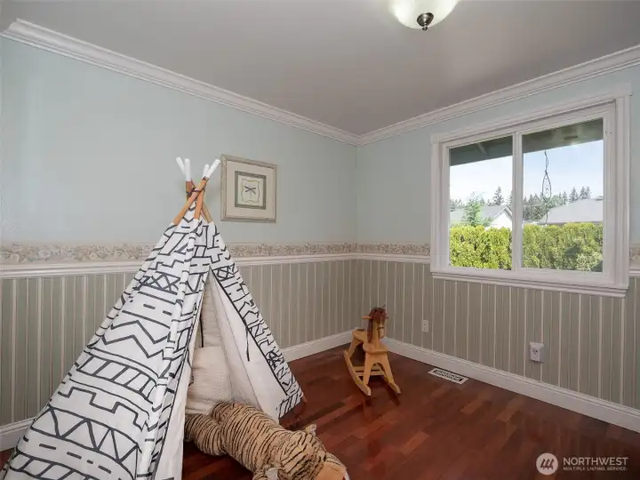 Third bedroom with crown molding, laminate flooring and cute decorative detailing.