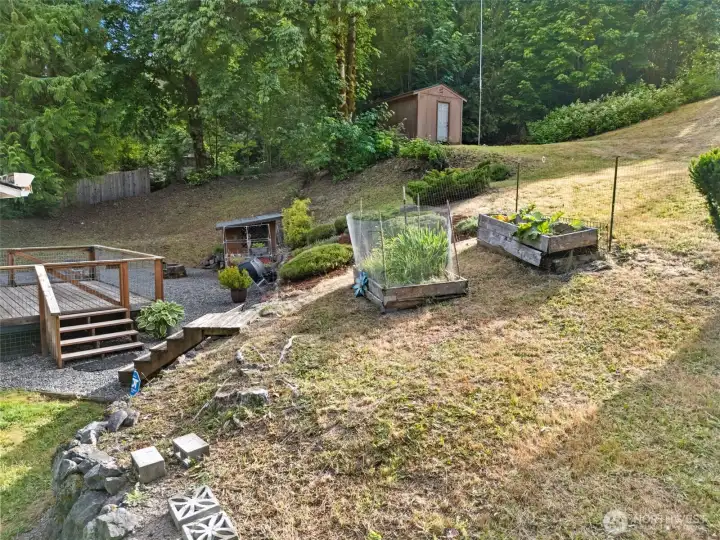 Back area with raised garden beds, a garden shed, a spacious storage shed, and low maintenance rock. Back area with raised garden beds, a garden shed, a spacious storage shed, and low maintenance rock.