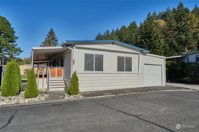 Front of home with covered porch and garage.