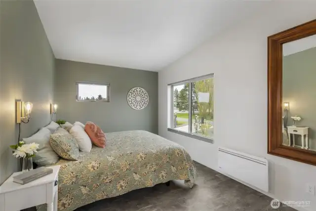 The primary bedroom offers soft, calming tones and beautiful light from two directions.
