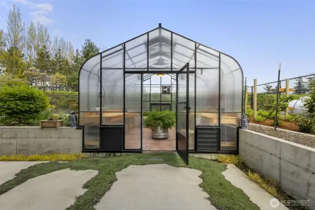 Inviting greenhouse entry with raised beds ready for growing season.