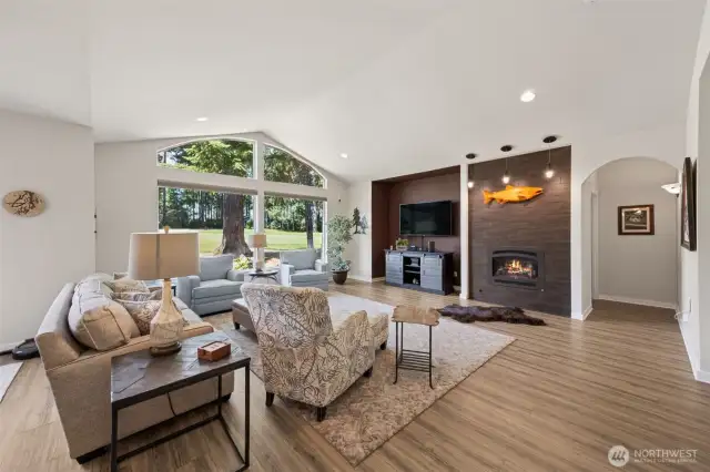 Vaulted great room overlooking the fairway -- cozy propane fireplace, large picture windows, and LVP flooring.