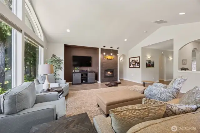 Living room has a vaulted ceiling, propane fireplace, and an entertainment nook.